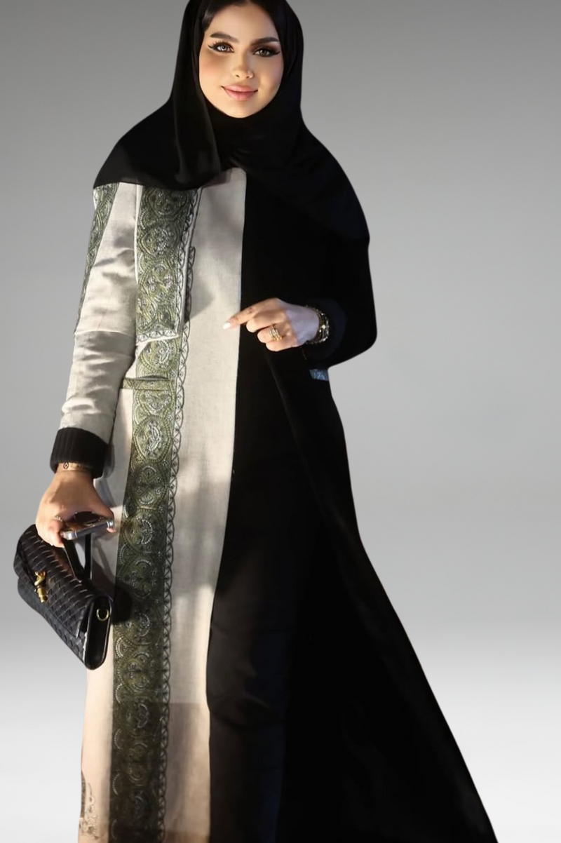 Black and beige abaya with green embroidered panel, combining modern sophistication with cultural elegance.
