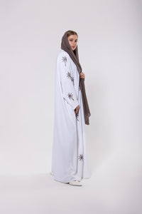 Abaya inspired by the palm trees of Qatar, featuring palm-inspired embroidery on lightweight and elegant fabric.