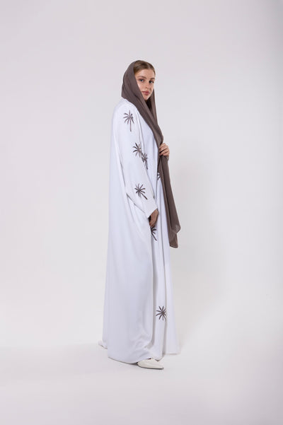 Abaya inspired by the palm trees of Qatar, featuring palm-inspired embroidery on lightweight and elegant fabric.