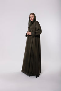 Abaya made from a soft leather and pure silk blend in olive-toned or classic dark hues, featuring a flowing modern cut with a rich, textured finish.