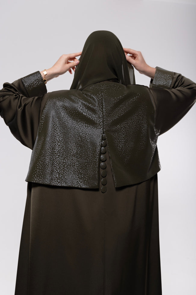 Abaya made from a soft leather and pure silk blend in olive-toned or classic dark hues, featuring a flowing modern cut with a rich, textured finish.