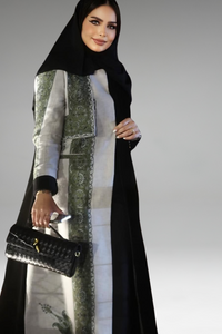 Black and beige abaya with green embroidered panel, combining modern sophistication with cultural elegance.