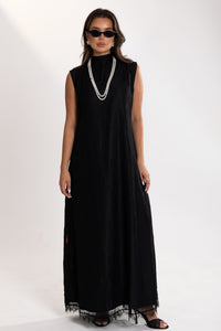 Woman wearing a black esme sleeveless dress with lace details on a white background