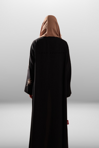 Black abaya with intricate gold embroidery featuring a palm tree motif in golden thread, exuding elegance and luxury.