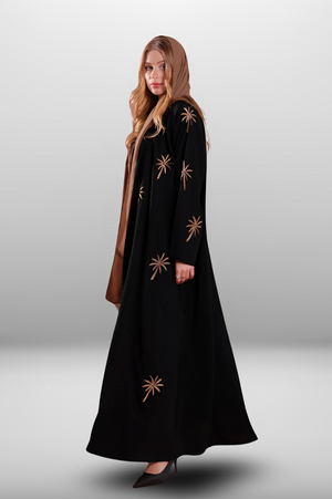 Black abaya with intricate gold embroidery featuring a palm tree motif in golden thread, exuding elegance and luxury.