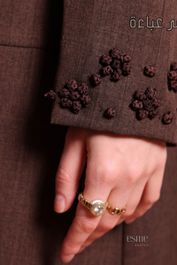 Deep brown coat-style abaya with front buttons, side pockets, and hand-embroidered detailing for a refined and stylish look.
