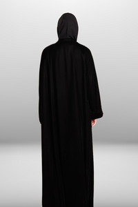 Deep black abaya with intricate embroidered detailing, showcasing luxurious velvet fabric and traditional craftsmanship.