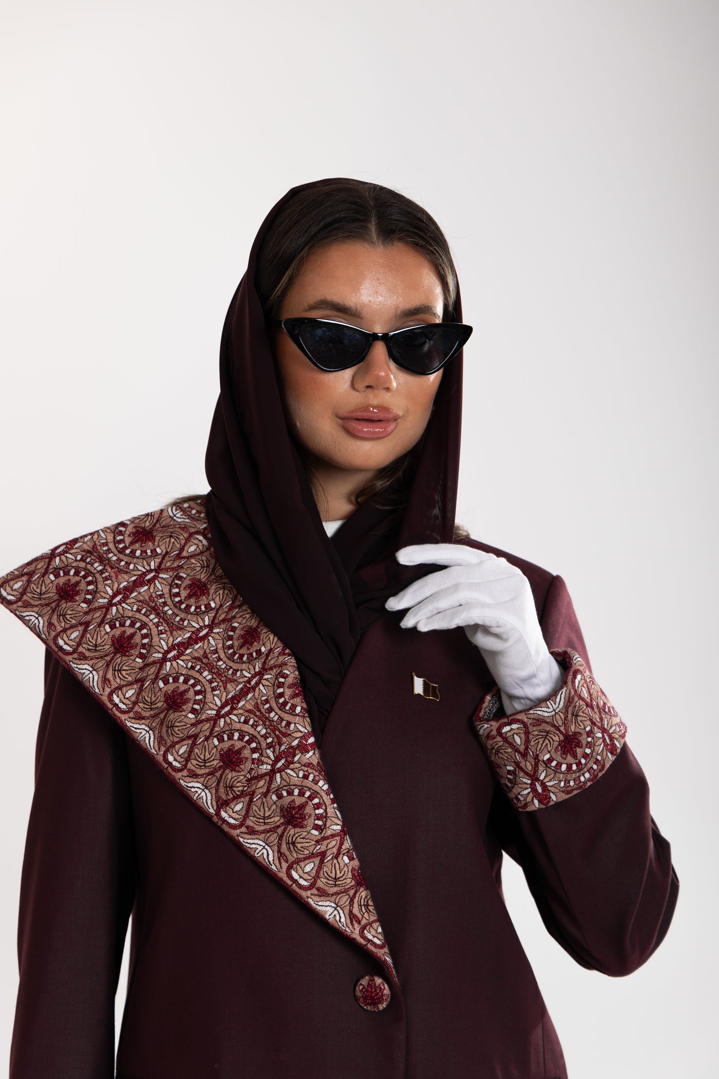 Woman wearing a burgundy embroidered blazer by esme abaya qatar