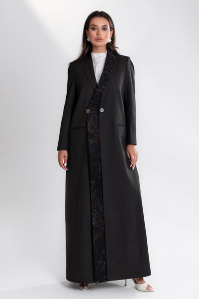Woman wearing a long black coat by esme on a white background