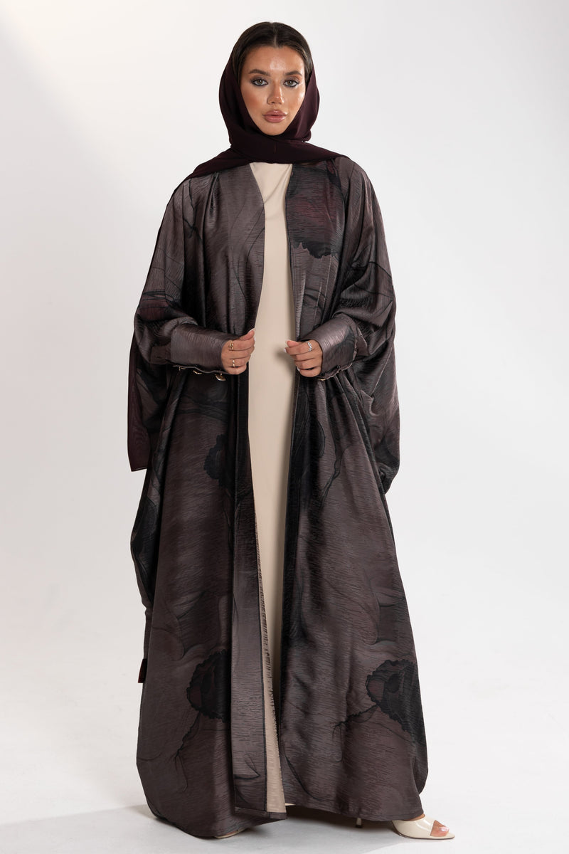 Woman wearing a dark  bisht abaya by esme with a white background