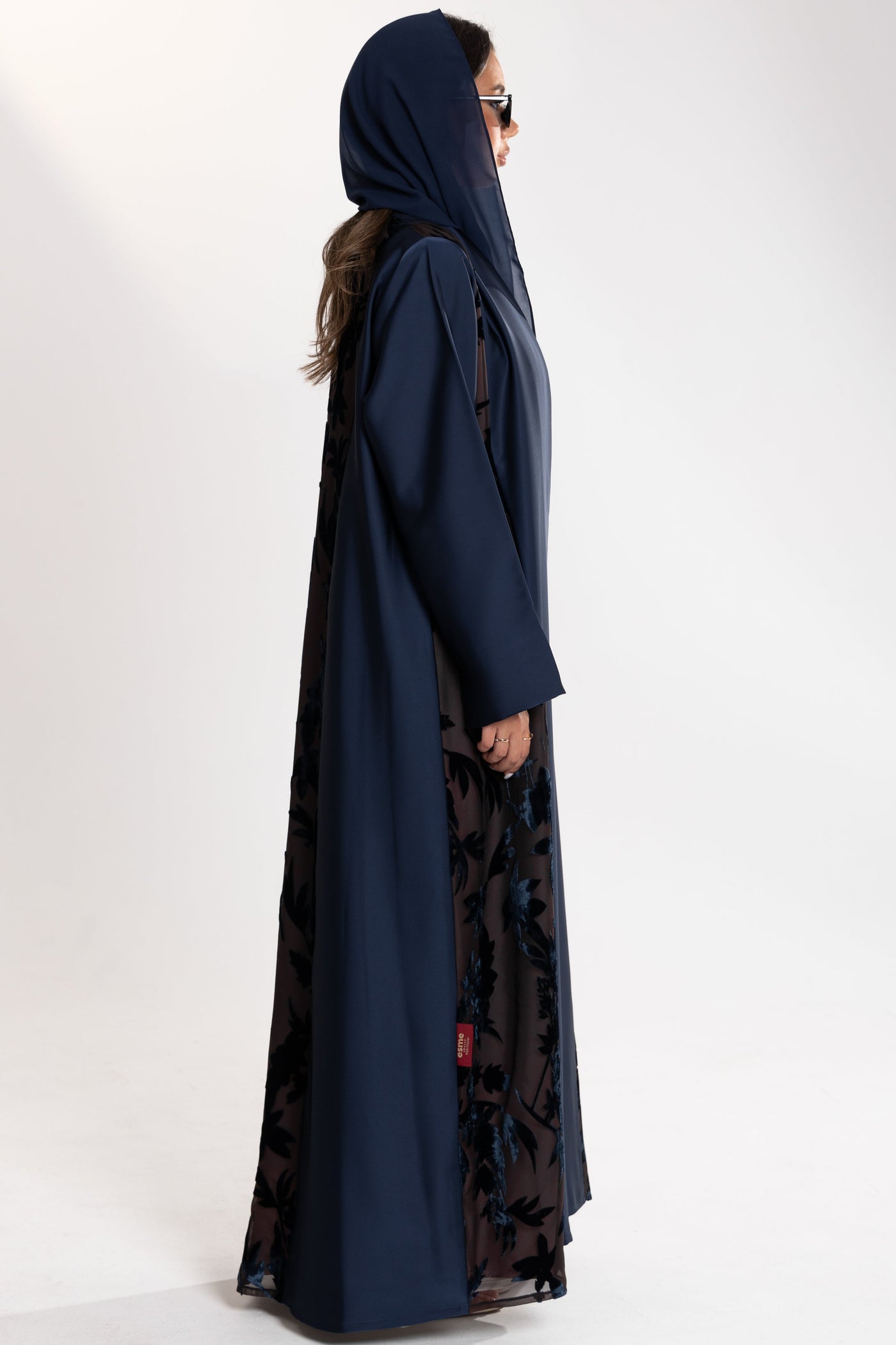 Woman wearing a long blue Esme Abaya with elegant velvet details, showcasing luxury abaya design in Qatar