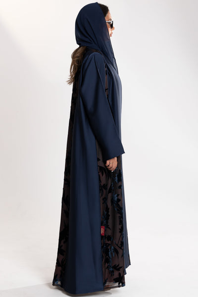 Woman wearing a long blue Esme Abaya with elegant velvet details, showcasing luxury abaya design in Qatar