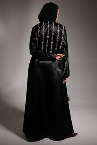 women wearing black abaya with traditional tatriz work on it 