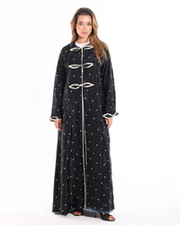 Side profile of The Bow Theory Abaya highlighting its flowing silhouette, rich patterned fabric, and elegant tailored finish.