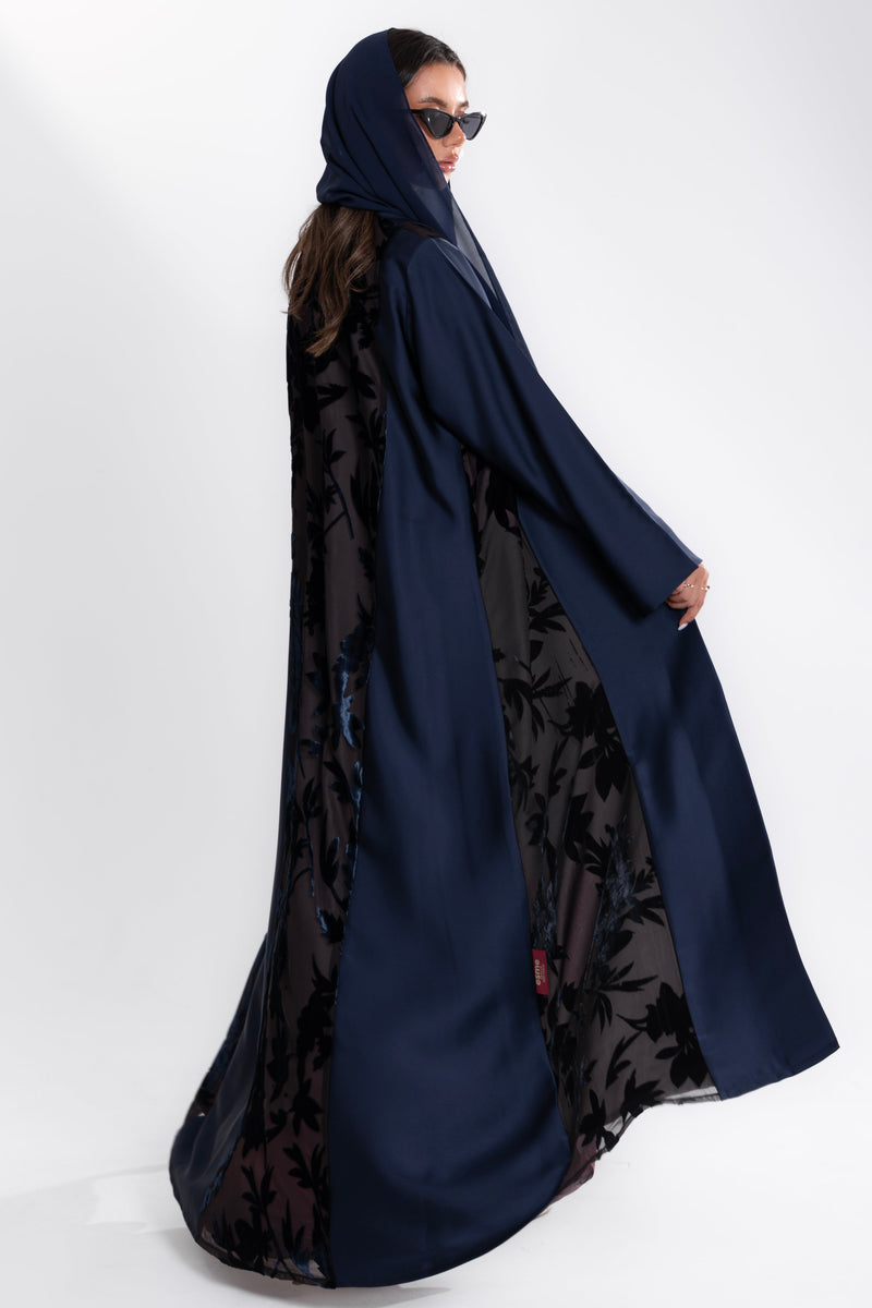 Woman wearing a long blue Esme Abaya with elegant velvet details, showcasing luxury abaya design in Qatar