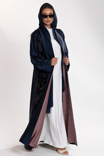 Woman wearing a long blue Esme Abaya with elegant velvet details, showcasing luxury abaya design in Qatar